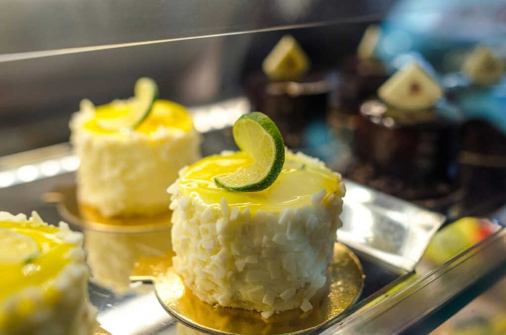 Delicious lime-decorated cakes with white chocolate on a pastry display.