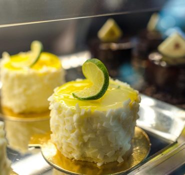Delicious lime-decorated cakes with white chocolate on a pastry display.