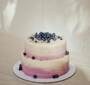 Two-tier blueberry cake with creamy frosting, perfect for celebrations.